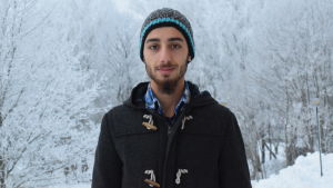 Rasim Al Sharkat tycker att Dalsbruk är en bra plats att börja på. Rasim Al Sharkat ser in i kameran, i bakgrunden ett vackert vinterlandskap med frostiga träd.