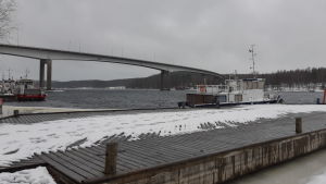 Bron över Puumala sund byggdes år 1993-1995. Om somrarna är det liv och rörelse i hamnen. Den höga bron i Puumala fotograferad från stranden.
