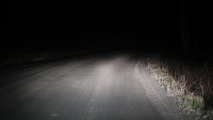 Vart tog gruset till vägen vägen frågar man sig längs Västeruddsvägen. En grusväg som lyses upp av bilens ljus.