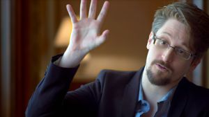 Aktivisti - Aktivisten. Edward Snowden med ena handen uppsträckt i ett hotellrum i Moskva / April 2019, Moskva