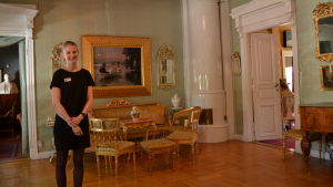 Guiden Maria Solin står i salongen. Guld var Hélène Jakobssons favoritfärg. Salongen i Ett hem