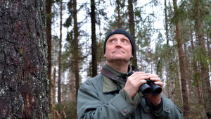 Fågelskådaren Magnus Östman värnar om fåglarnas möjlighet att få häcka i lugn och ro. Fågelskådare spejar i skog.