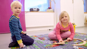 Fem år gamla Eelis Mäki och Seela Raita går i daghemmet Laban. Seela gillar att leka medan Eelis gillar att äta på dagis. Dagisbarnen Eelis Mäki och Seela Raita leker på en bilmatta.