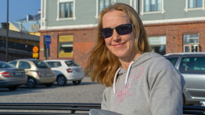 Att återvinna sitt plastavfall är ingen ny grej för Sirpa Hopeamaa. Sirpa Hopeamaa sitter på en bänk i solen.