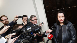 Grundlagsutskottets ordförande Johanna Ojala-Niemelä möter journalister i trängsel i samband med utskottsmöte. Grundlagsutskottets möter journalister i trängsel i samband med utskottsmöte.