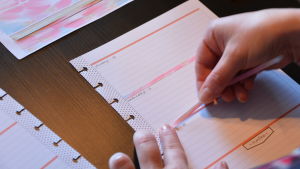 Det börjar med ett vitt papper som med hjälp av klistermärken... Ett vitt kalenderblad. Limmar ett rosa långt och smalt klistermärke mellan dagarna.