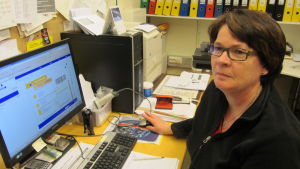 Köpman Monica Brunberg vid lantis lär sig postsedier. Köpman Monica Brunberg lär sig postservice via nätstudier