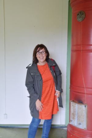 Majbritt Huovila och en tjusig kakelugn Konstnären Majbritt Huovila inne i Linnas butik
