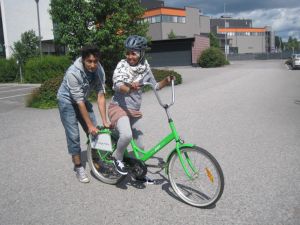 En flicka lär sig cykla med hjälp av Carlos Markkanen En flicka får hjälp att lära sig cykla