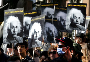 Demonstration för flyktingar i Los Angeles. Demonstranter bär skyltar med Albert Einsteins bild och texten flyktingar är välkomna.