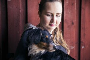 Nicole Hellberg sitter med en hund i famnen.