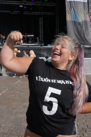 Fokusera på det din kropp klarar av. Då utövar du kroppspositivism. Sara Dahlström står framför en utomhusscen. Lyfter ena armen och spänner musklerna. Ser väldigt glad ut.