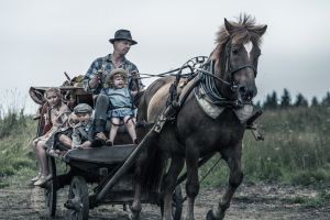 Filmbild av man och barn på hästkärra
