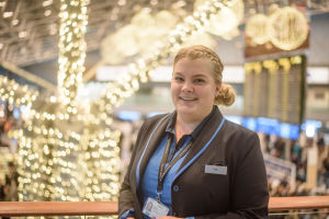 Lotta Karppinen står framför en julpyntad flygplatsterminal.