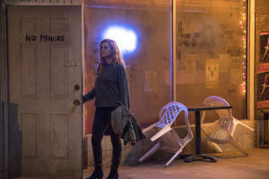 Amy Adams on Camille Preaker sarjassa Sharp Objects. Nainen avaa oven, jossa lukee No minors.