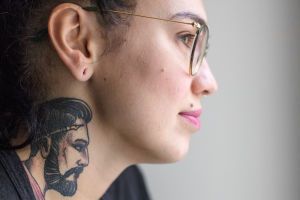Lähikuva Natalia Tolmatsovan kaulalle tatuoidusta mieshahmosta.
