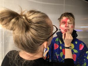 Maskeeraaja Tarja Virmanen viimeistelee Miikka Koiviston kasvomaalausta. Normal Life -yhtyeen Miikka Koivisto maskeerattavana