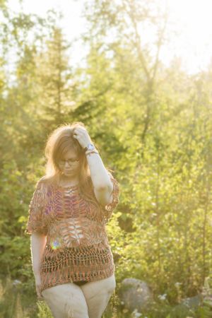 Alexandra avbildar sin kropp både i fotografier och målade tavlor. Det har gett henne en mer verklig bild av hur hon ser ut. En kvinna iklädd underkläder och en glest virkad tröja. Hon står i en dimmig skog och solen lyser från ena hörnet. Hon tittar ner i marken.