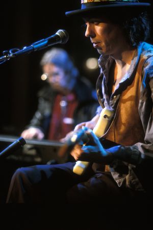 Dave Lindholm mikrofonin takana. Dave Lindholm esiintyy Tampereella 1992. Taustalla pianisti Nicky Hopkins.