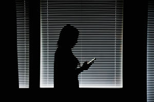 Heli började sockerdejta för att hon behövde pengarna. Kvinna med telefon i mörkt rum.