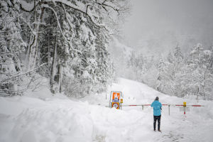 Man står framför en avstängd väg nära Untertauern i Österrike den 7 januari 2019. Lavinfara nära Untertauern i Österrike den 7 januari 2019.