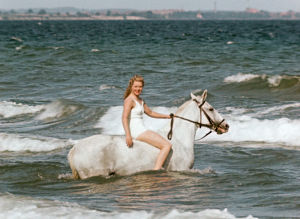 Nainen valkean ratsun selässä meren aalloissa. Kuva elokuvasta Muuttolintu (Opfergang), 1944.