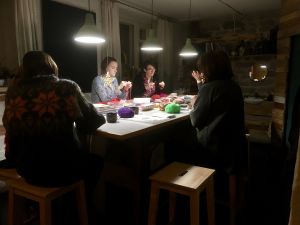 Feministiska kvinnoklubben i full koncentration. Kadi Viik i mitten, med glasögon på. Damer sitter runt ett bord och stickar
