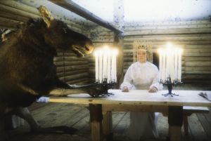 Näyttelijä Pirkko-Liisa Tikka morsiamen roolissa tv-sarjassa Rauta-aika. Hirvi ja morsian pöydän ääressä. 