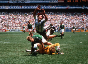 Maradona taistelee pallosta länsi-saksalaisen maalivahdin Harald "Tony" Schumacherin ja puolustaja Karlheinz Försterin kanssa Meksikon MM-kisojen finaalissa vuonna 1986. Jalkapalloilija Diego Maradona kaatuu saksalaisten pelaajien, Harald Schumacherin ja Karl-Heinz Försterin yli vuoden 1986 Meksikon maailman mestaruuskisoissa.