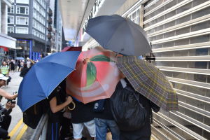 Ungdomar såg med sina paraplyer till att det var omöjligt att identifiera personen som målade graffiti på Bank of China. Ungdomar såg med sina paraplyer till att det var omöjligt att identifiera personen som målade graffiti på Bank of China.