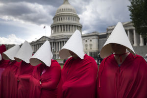Women dressed as handmaids demonstrated against funding cuts to Planned Parenthood outside the National Capitol in Washington