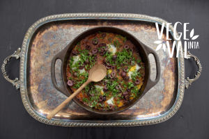 En vegetarisk Shaksuka i en gjutjärnsgryta på en silverbricka. Högs upp till höger finns Vegval/Vegevalintas logotyp.