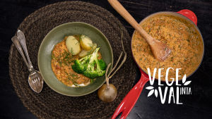 Vegetarisk tomatgryta fotograferad uppifrån. På tallriken finns även potatis och en bit broccoli.
