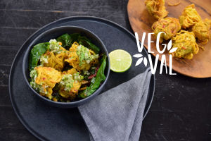 Vegetarisk mat fotad snett uppifrån. Maten är upplagd på en svart tallrik.