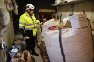 Konstruktionsplanerare Ari Leppäniemi berättar att man noggrant mäter upp ingredienserna till det nya murbruket. Mies esittelee laastivarastoa