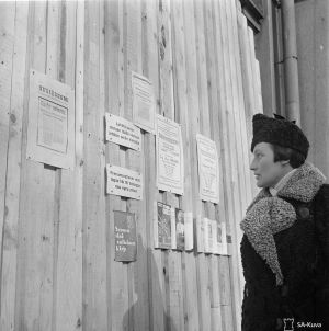 Helsinkiläisrouva lukee uutista rauhan solmimisesta 13.3.1939.
