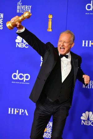 Stellan Skarsgård firar med sitt pris för bästa manliga biroll. Stellan Skarsgård firar på röda mattan.