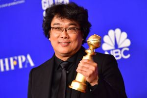 Sydkoreanska regissören Bong Joon Ho och priset för bästa film på främmande språk. Sydkoreansk regissör med vinstpokal.