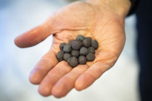 I dagens läge blandas järnpellets med koks i masugnen, för att reducera järnet. I Hybritprocessen är det vätgas som ska användas i stället. Järnpellets, alltså små svarta kulor i ungefär 1 cm i diameter, i en hand.