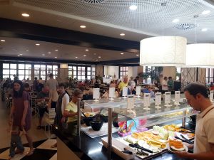 Hotellet Costa Adeje Palace ligger på den södra delen av ön Teneriffa. En frukostbuffé och en restaurangmatsal med en massa hotellgäster.