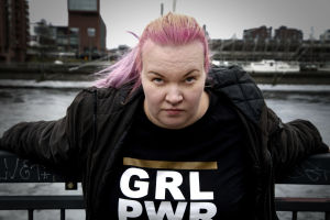 Evaleena Vuorenmaa Nojaa käsillään sillan kaiteeseen ja katsoo tiukasti kameraan.