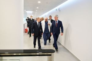 Vladimir Putin och Sergej Sobjanin besökte ett sjukhus där personer med covid-19 vårdas i Moskva. Putin och Sobjanin går i en vit korridor, följda av en läkare i vit läkarrock och en massa människor.