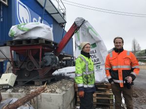 Anna Yrjänen och Sampo Tukiainen framför en kvarn som mal biokol som ska skickas till USA. anna yrjänen och sampo tukiainen framför biokolkvarn