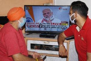 Sjukvårdare tittar på premiärminister Narendra Modi som håller tal i tv 14.4.2020. Hälsovårdspersonal tittar på premiärminister Narendra Modi i tv 14.4.2020