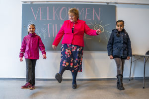 När skolorna för de yngre eleverna öppnade i Norge den 27.4 övade statsminister Erna Solberg trygga sätt att hälsa på varandra med barnen. Erna Solberg övar distanshälsningar med två skolelever.