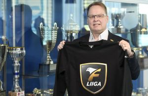 Kimmo Nurminen poserar med en t-skjorta med ligans nya logo. Kimmo Nurminen poserar med en t-skjorta med ligans nya logo.