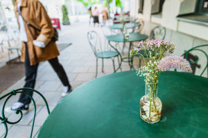 Uteserveringssäsongen är här och krögarna hoppas på soliga dagar, eftersom kunder i hög grad nu vill sitta utomhus. Tomma bord med blomvas på, på uteservering.