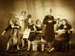 Merry Ladies -yhtyeen 10-vuotispotretti. Kuva on imitaatio Riinan isoäidin Ulla Katajavuoren Mickie-Maus -yhtyeen muotokuvasta. Vanhahtavassa 10-vuotisjuhlakuvassa Merry Ladies -yhtye poseeraa instrumenttien kanssa