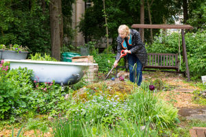 Odlingslotten blomstrar, men inte utan arbete. Harriet Abrahamsson på sin odlingslott i Toimela odlingsträdgård.