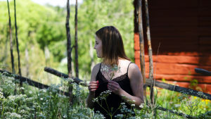 Sofia Svevar framför en gärdesgård